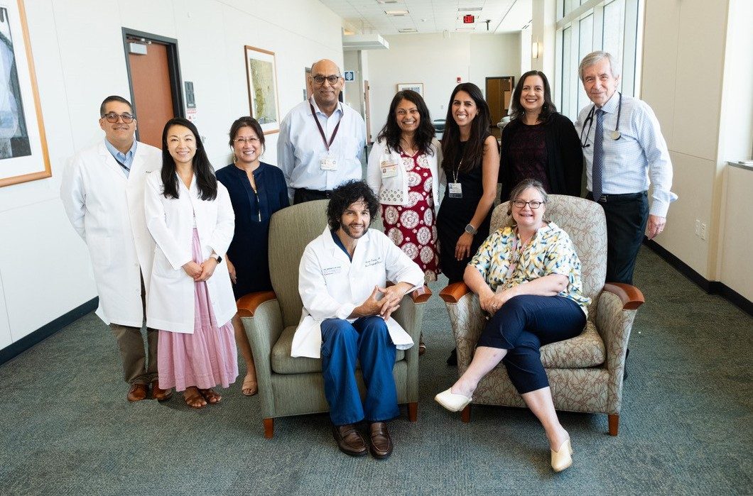 Medium group of people posed around two people seated in chairs