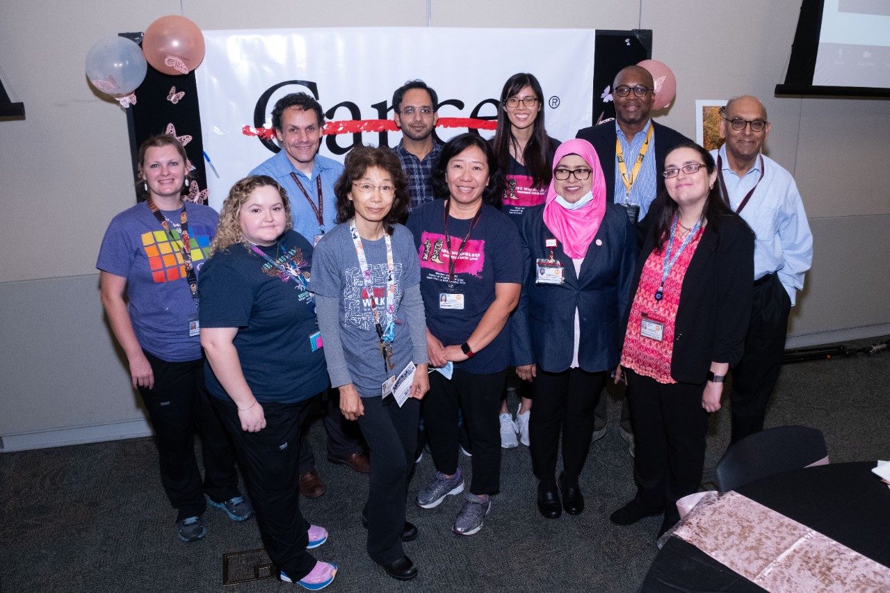 Eleven people posting in front of a cancer strikethrough sign