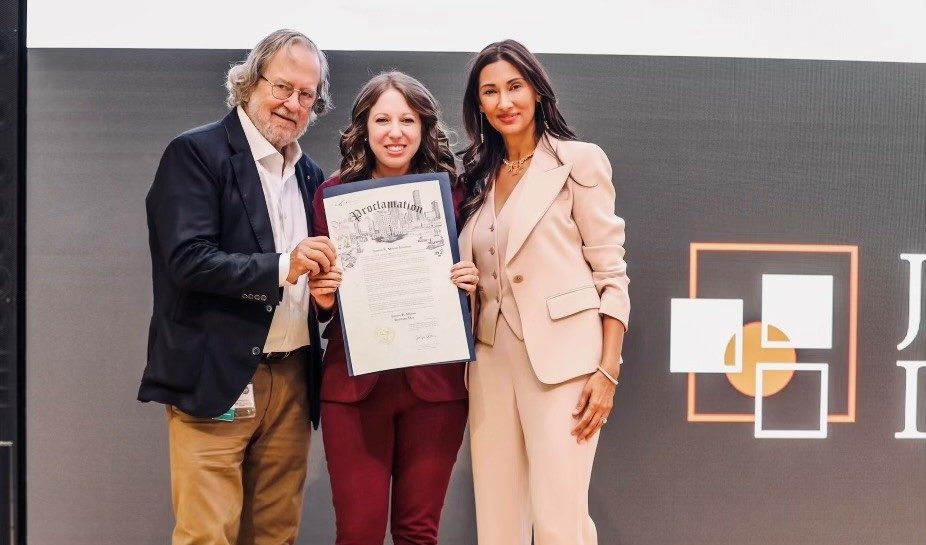 Three people posing with a proclamation 