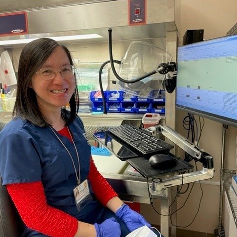 Woman working in a lab and smiling