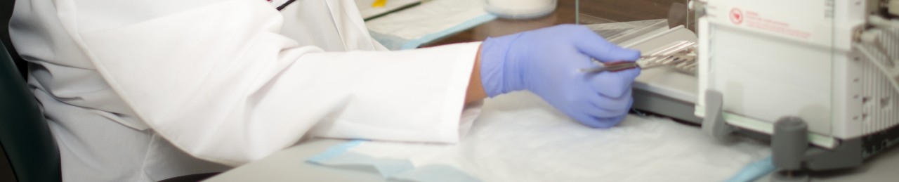 A hand holds a sample in a machine